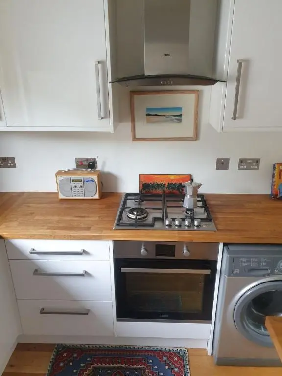 a kitchen with a stove and a washing machine at 1 Bed Apartment Inverness with City Views in Inverness