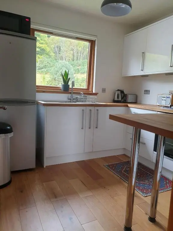 a kitchen with white cabinets and a window at 1 Bed Apartment Inverness with City Views in Inverness