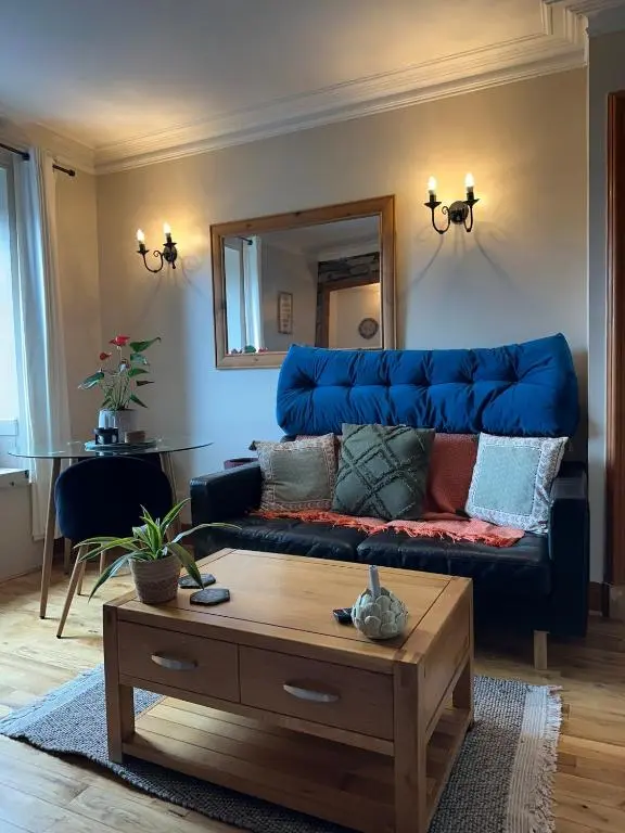 a living room with a blue couch and a mirror at Serendipity The Apartment in South Kessock