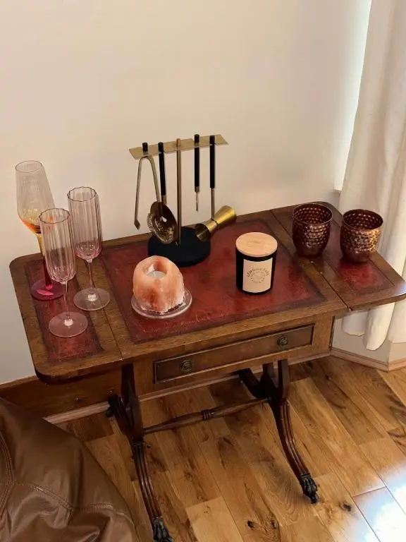 a wooden table with wine glasses and a plate of food at Serendipity The Apartment in South Kessock