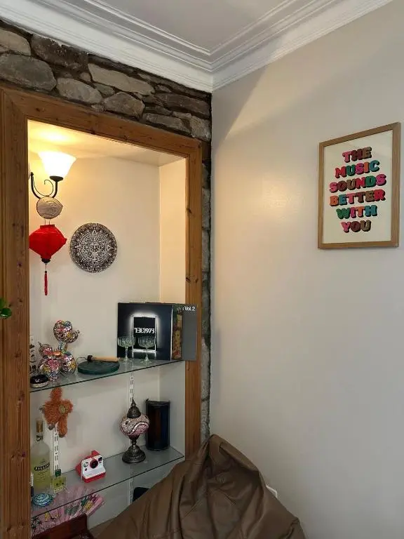 a living room with a stone wall and a shelf at Serendipity The Apartment in South Kessock