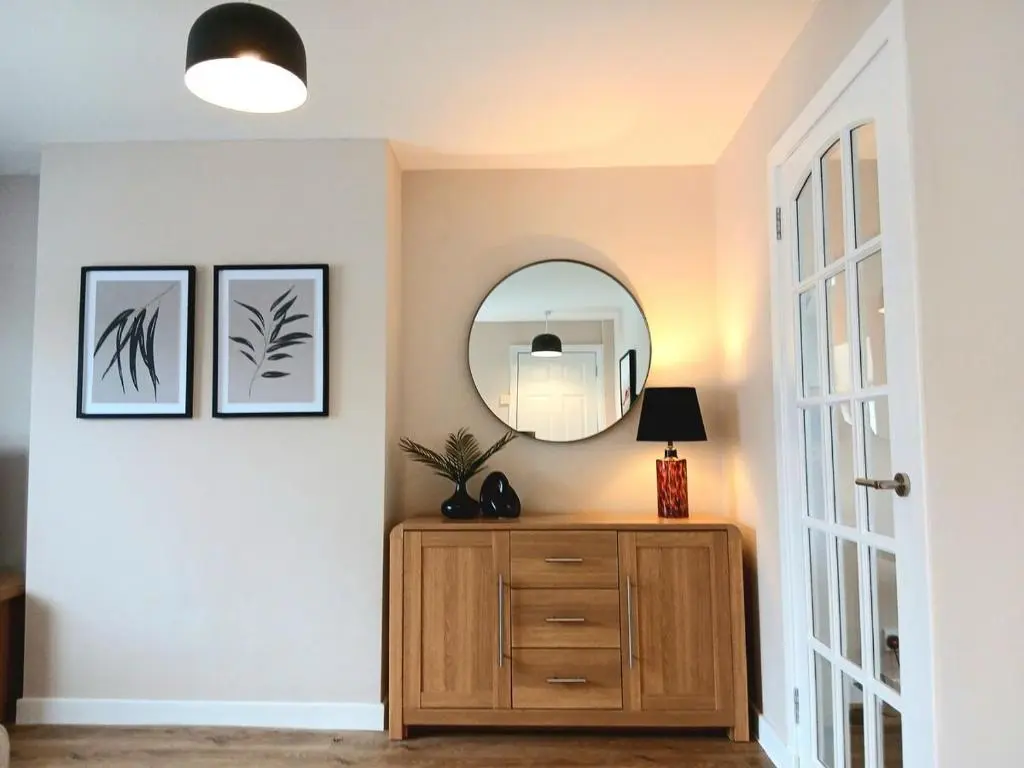 a room with a wooden dresser and a mirror at Newly refurbished 3 bed house in Inverness