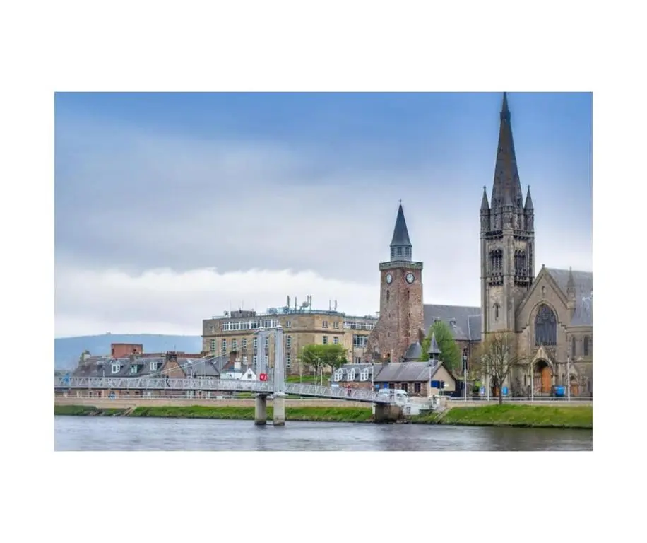 a city with a river and a bridge and buildings at Newly refurbished 3 bed house in Inverness