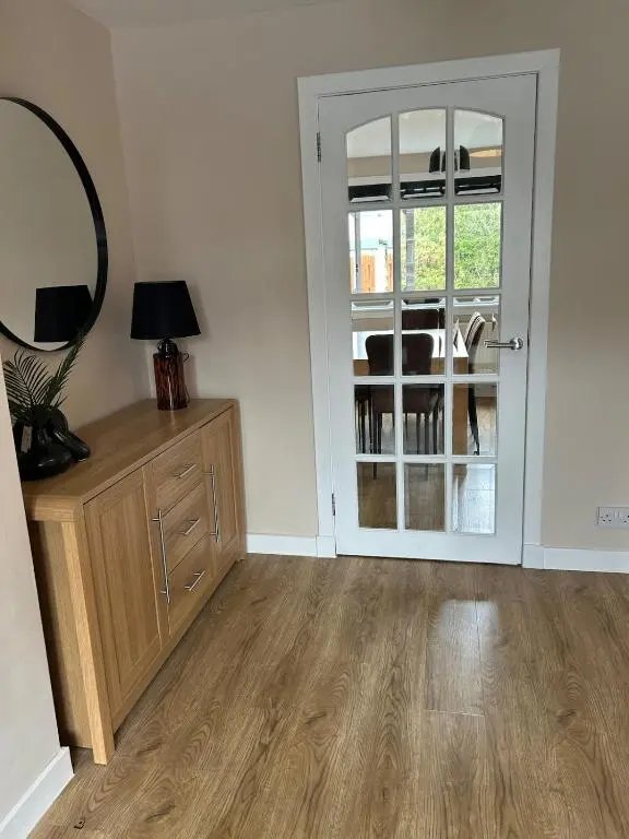a room with a door with a mirror and a table at Newly refurbished 3 bed house in Inverness