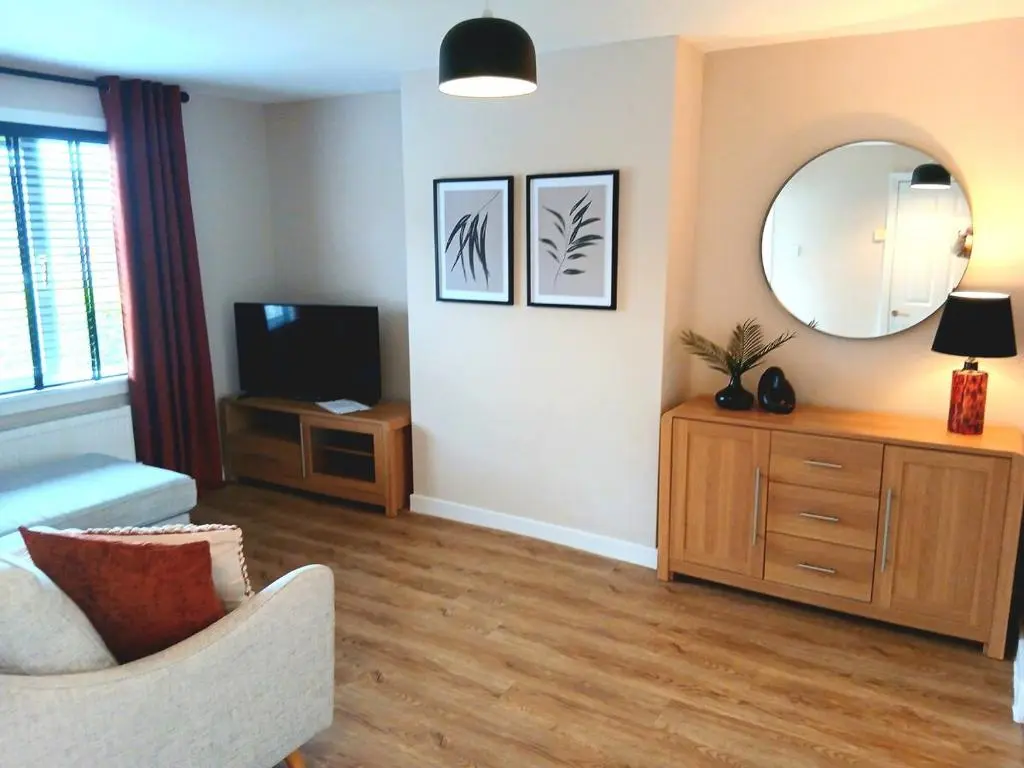 a living room with a mirror and a tv at Newly refurbished 3 bed house in Inverness