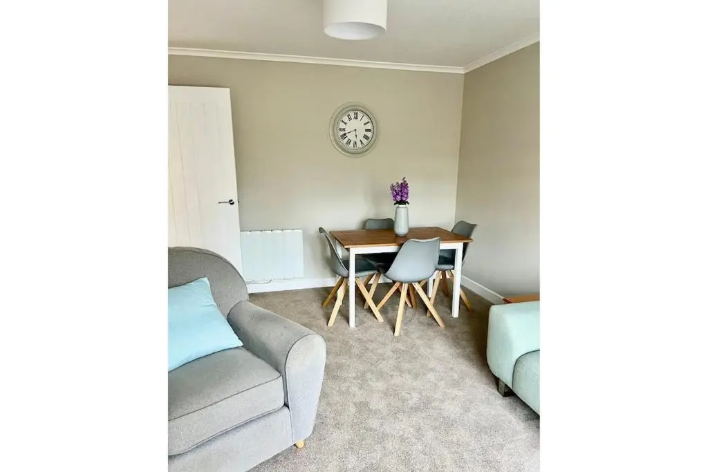 a living room with a couch and a table at Flat by the Firth - Stay in the heart of Nairn in Nairn