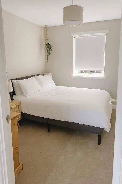a bedroom with a white bed and a window at Flat by the Firth - Stay in the heart of Nairn in Nairn