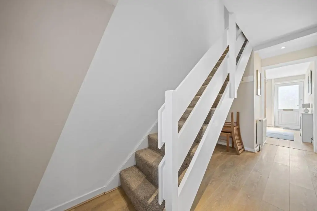 a staircase in a living room with white walls at Heather 3 Bedroom House - Inverness in Inverness