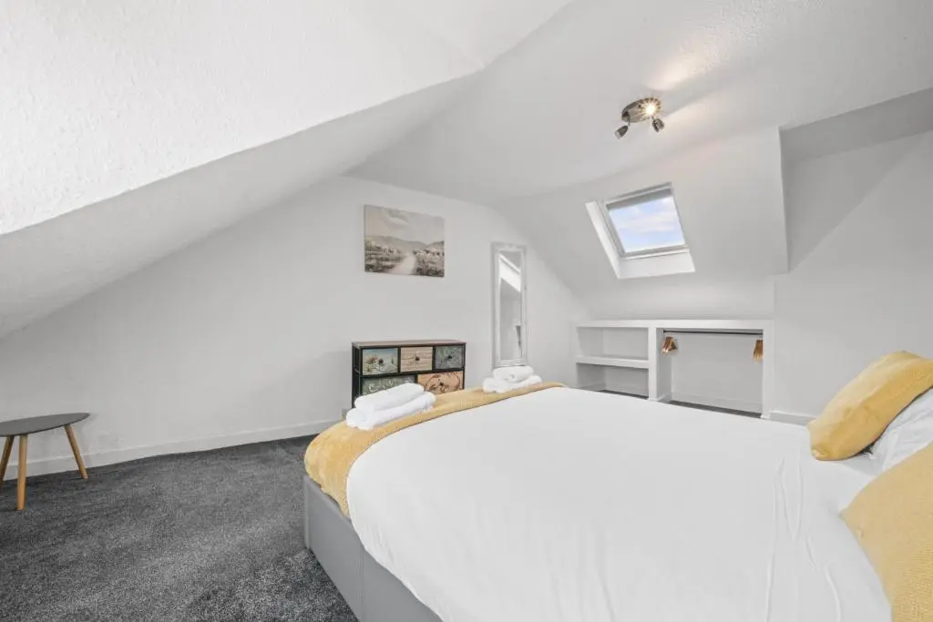 a white bedroom with a large bed and a table at Crown 3 Bedroom Apartment - Inverness in Inverness