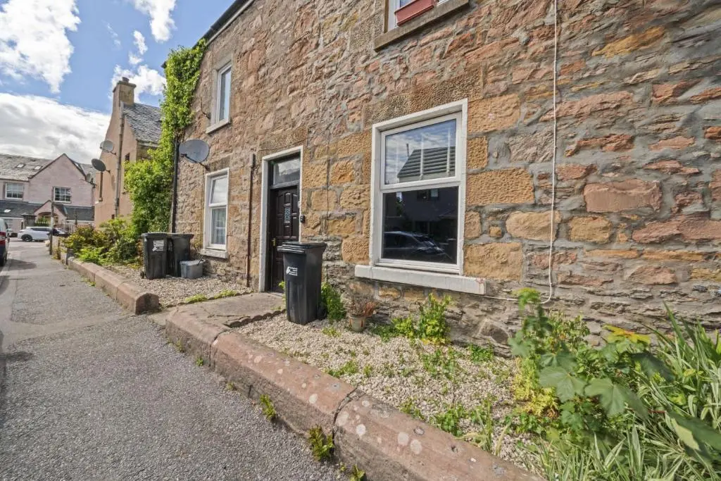 a brick building with two trash cans in front of it at Crown 3 Bedroom Apartment - Inverness in Inverness