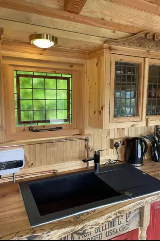 a kitchen with a sink in a wooden kitchen at Holiday Home Shepherds Hut by Interhome in Balnain
