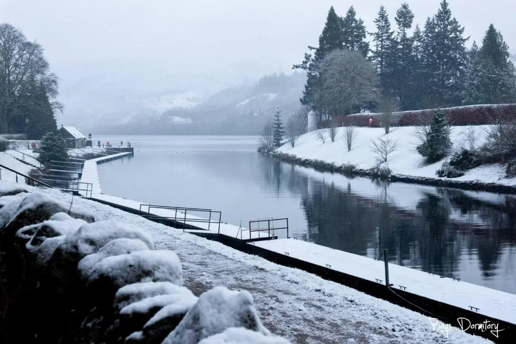 a body of water with snow on the ground at Bailem Lodge at Loch Ness ADULTS ONLY in Fort Augustus