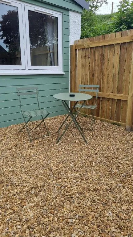 two chairs and a table in front of a house at Bailem Lodge at Loch Ness ADULTS ONLY in Fort Augustus