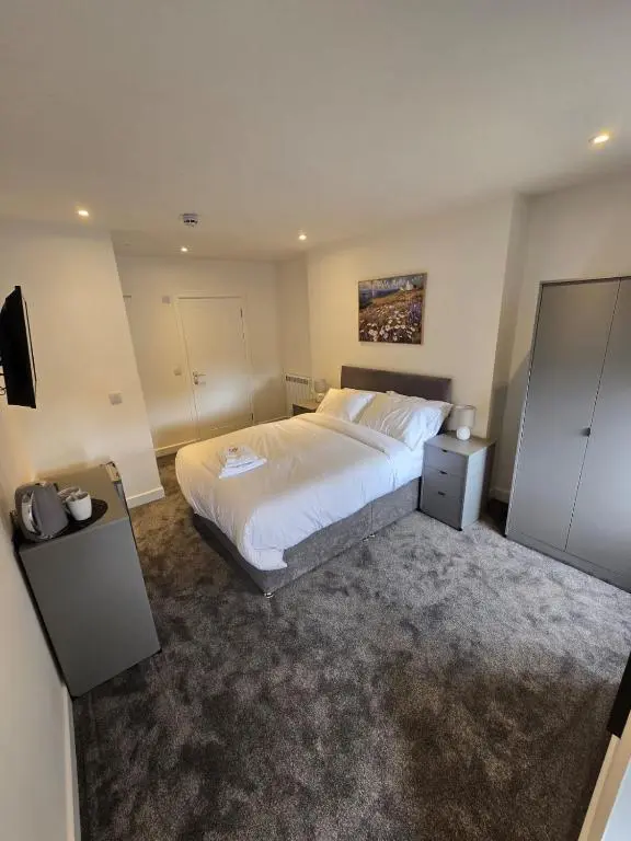 a bedroom with a large white bed and a television at Taigh Mor in Elgin