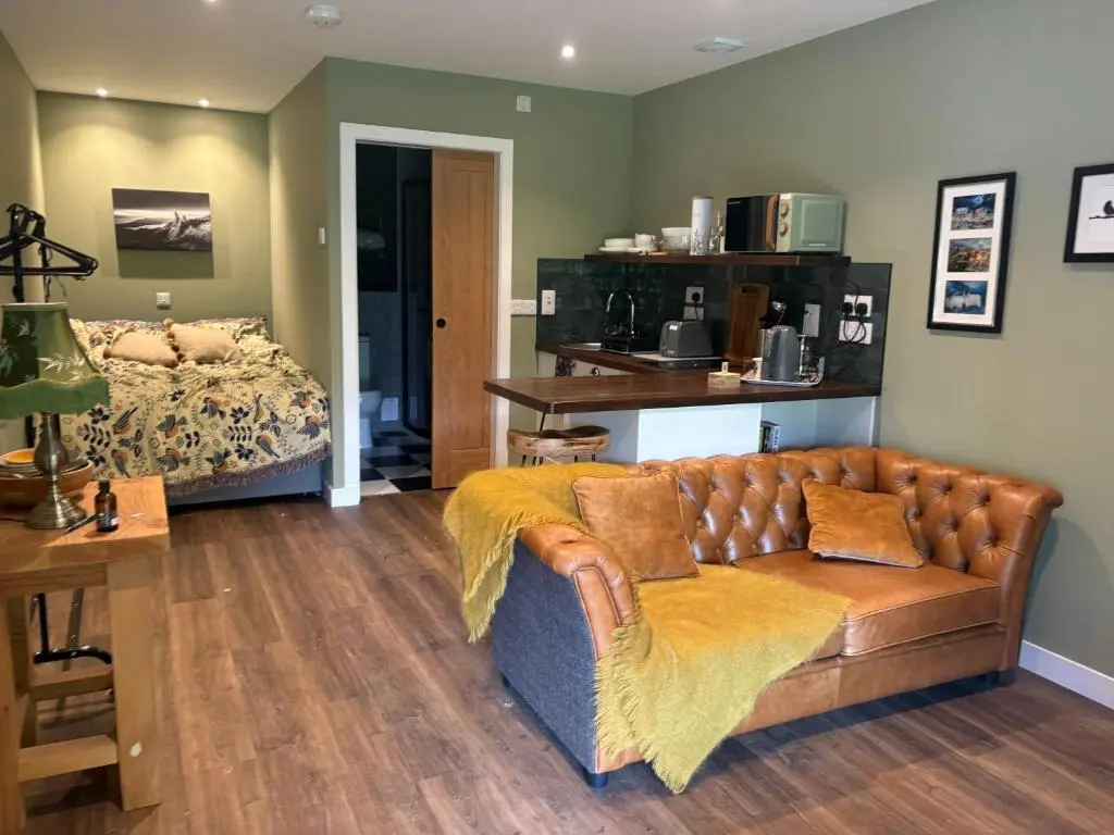 a living room with a couch and a bed at The Studio at Rannagowan in Ballater