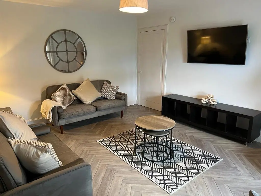 a living room with a couch and a table at 1 Links Place in Nairn