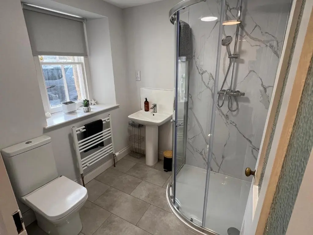 a bathroom with a shower and a toilet and a sink at 1 Links Place in Nairn