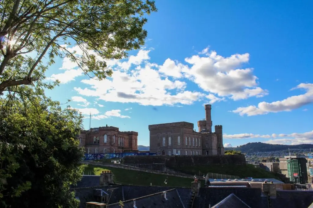 an old building on a hill with a blue sky at View Apartment in Inverness