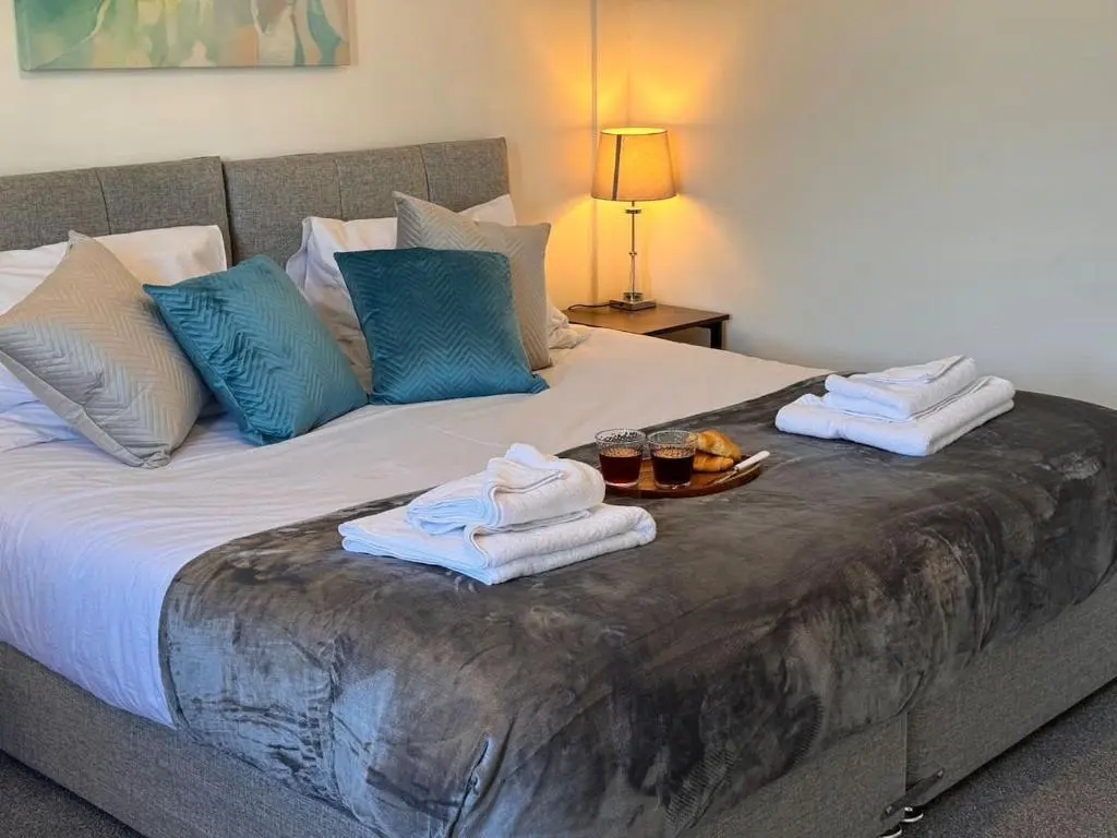 a bed with towels and bowls of fruit on it at Coorie House in Elgin in Elgin