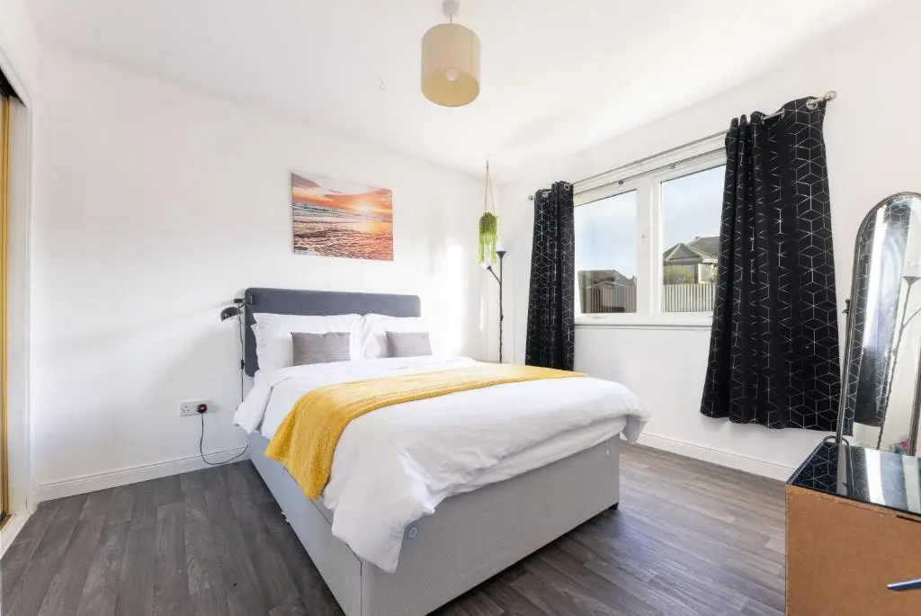 a white bedroom with a bed and a window at Lochnomore - A Luxury Home With Magnificent Views in Nairn