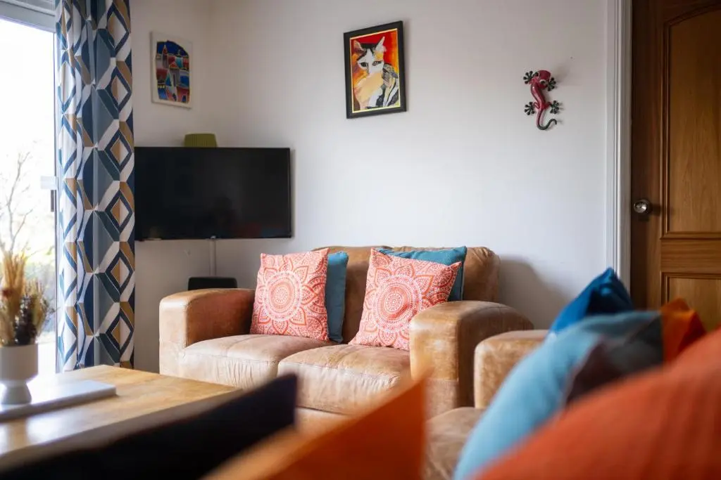 a living room with a couch and a tv at Lochnomore - A Luxury Home With Magnificent Views in Nairn