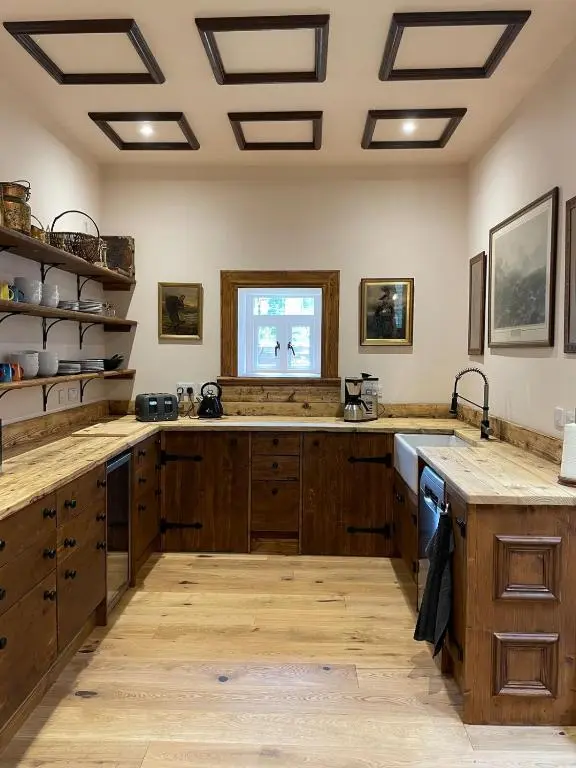 a large kitchen with wooden cabinets and a window at Church Brae in Tomatin