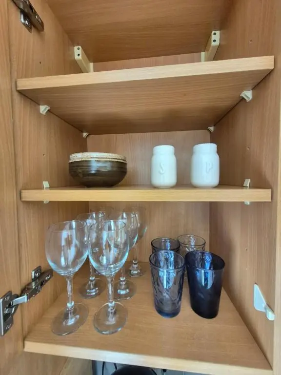 a shelf with wine glasses and bowls on it at Riverside Gardens in Dalneigh