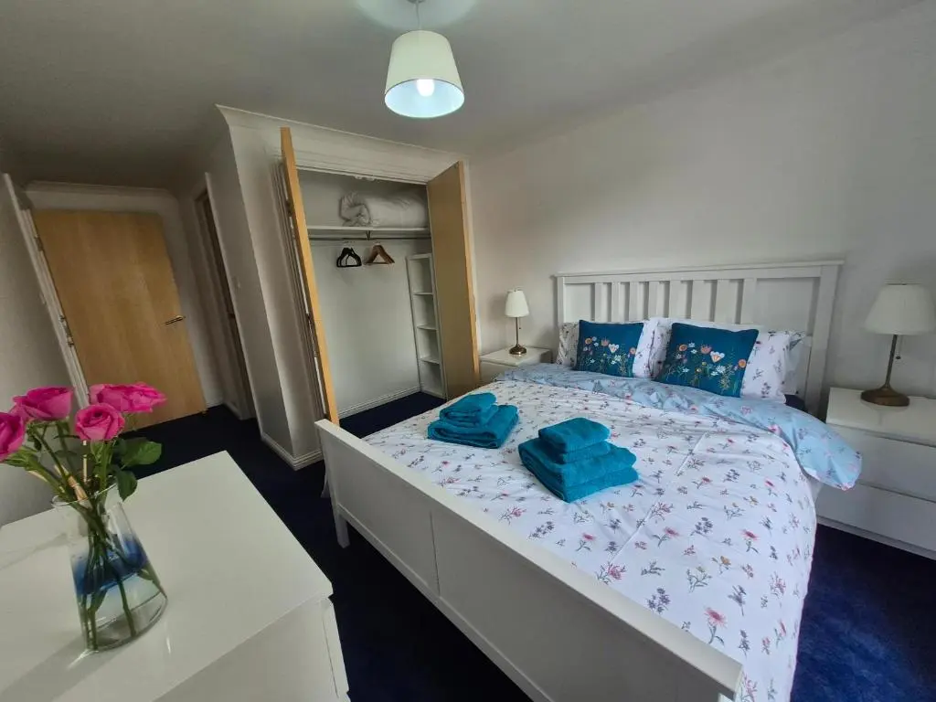 a bedroom with a bed with blue towels on it at Riverside Gardens in Dalneigh