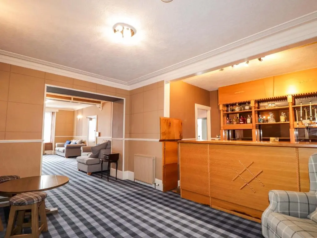 a hotel room with a bar and a living room at Crannoch Self Catering in Buckie