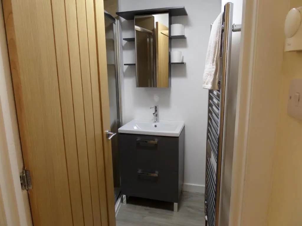 a small bathroom with a sink and a mirror at Church Street Apartments in Inverness