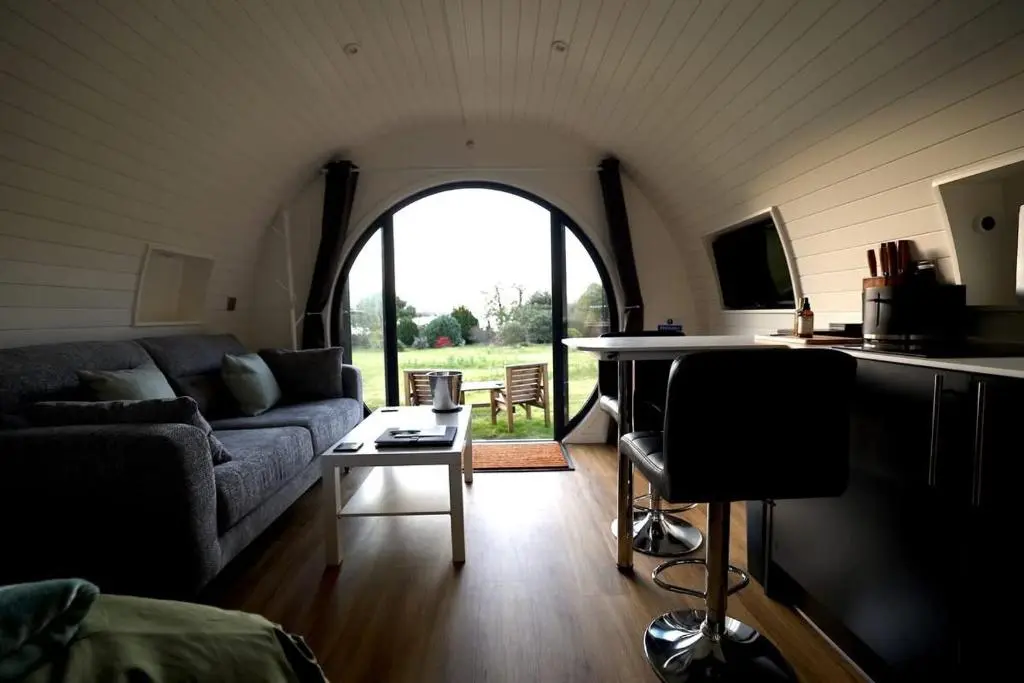 a living room with a couch and a table at Lochend Pods - Deas Pod in Inverlael