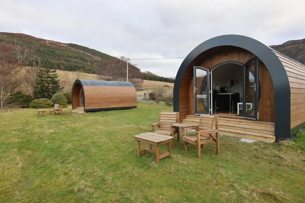 a small cabin with a table and chairs in a field at Lochend Pods - Deas Pod in Inverlael