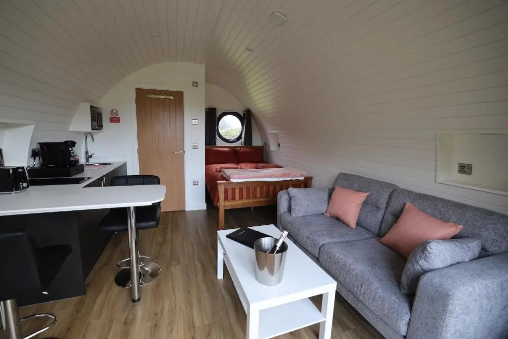 a living room with a couch and a table at Lochend Pods - Cl\u00ec Pod in Inverlael