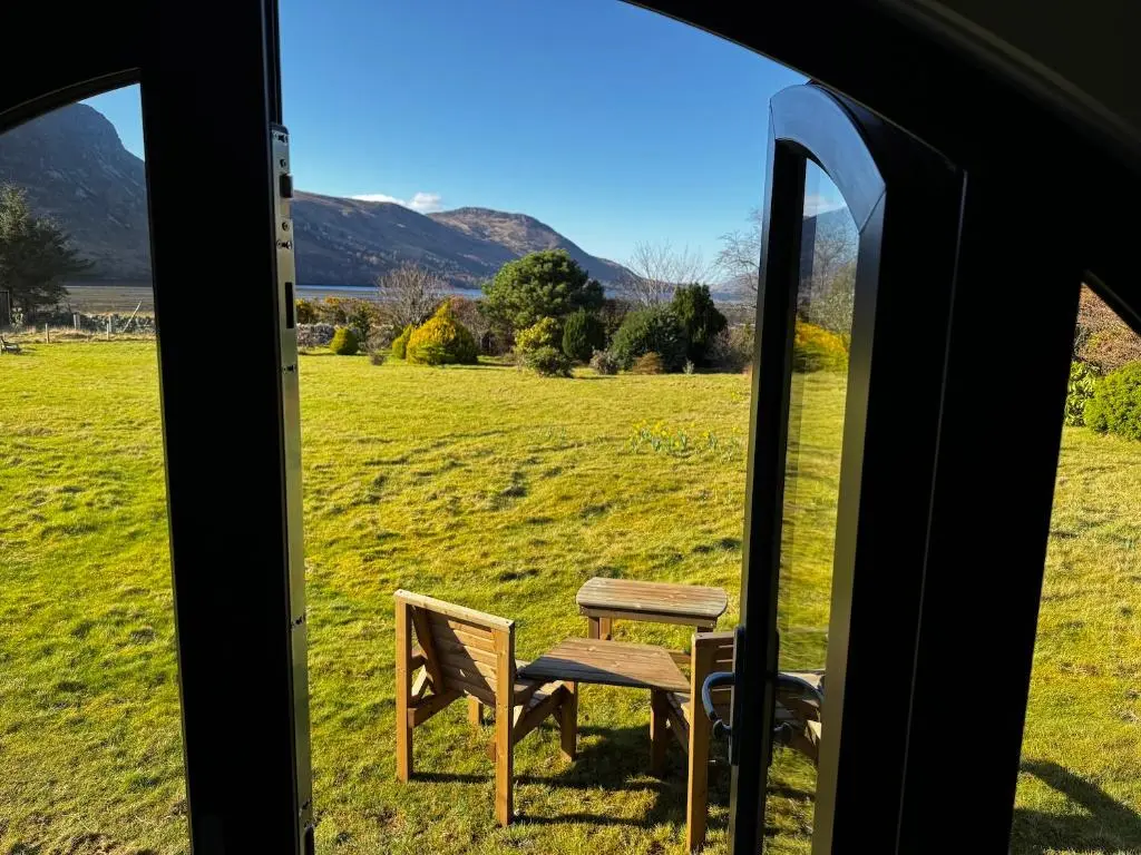 a table and chairs in a tent with a view of a field at Lochend Pods - Cl\u00ec Pod in Inverlael