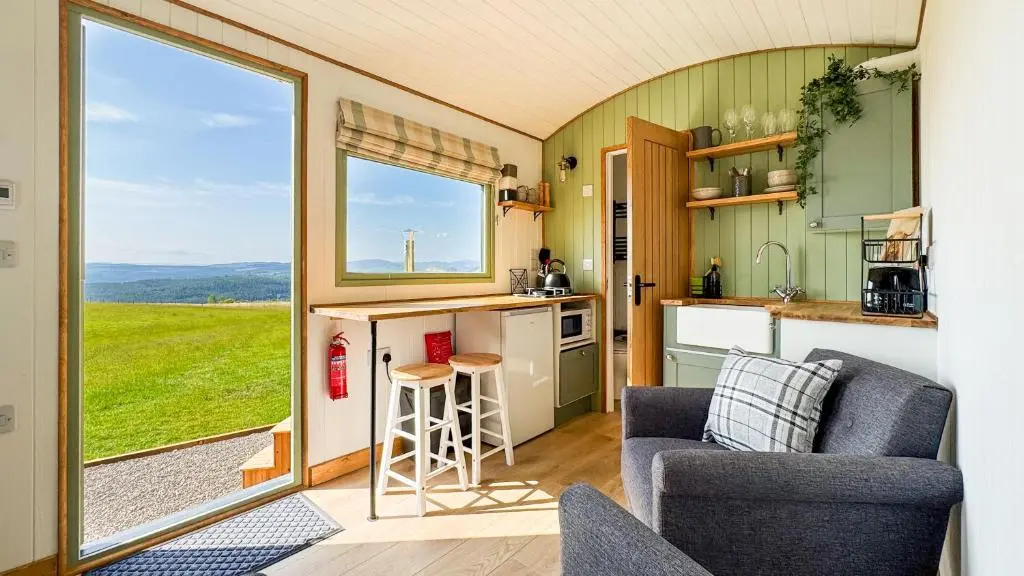 a kitchen and living room in a tiny house at Cnocvann Croft Shepherd Huts in Kilmorack