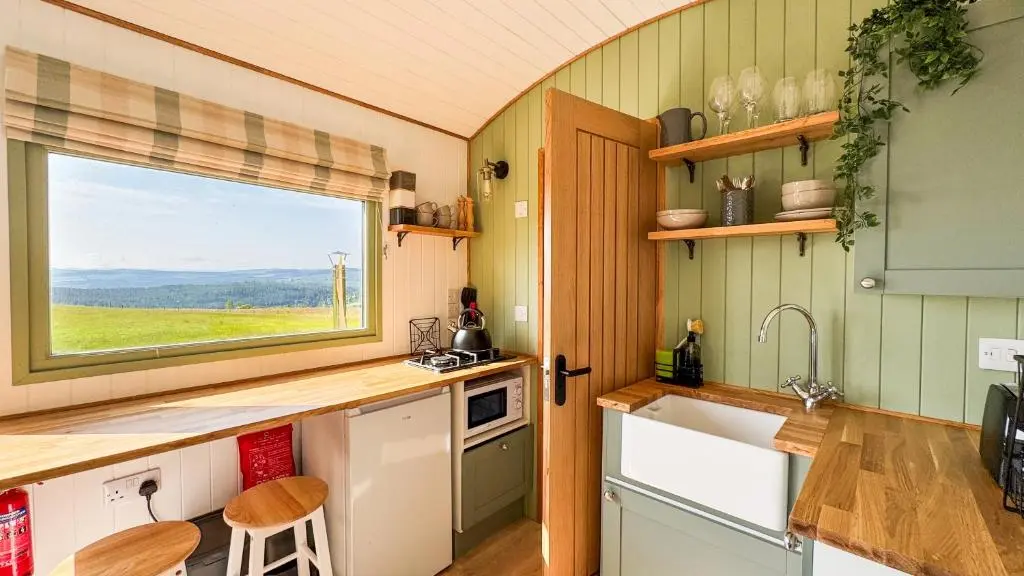 a kitchen with a sink and a window at Cnocvann Croft Shepherd Huts in Kilmorack