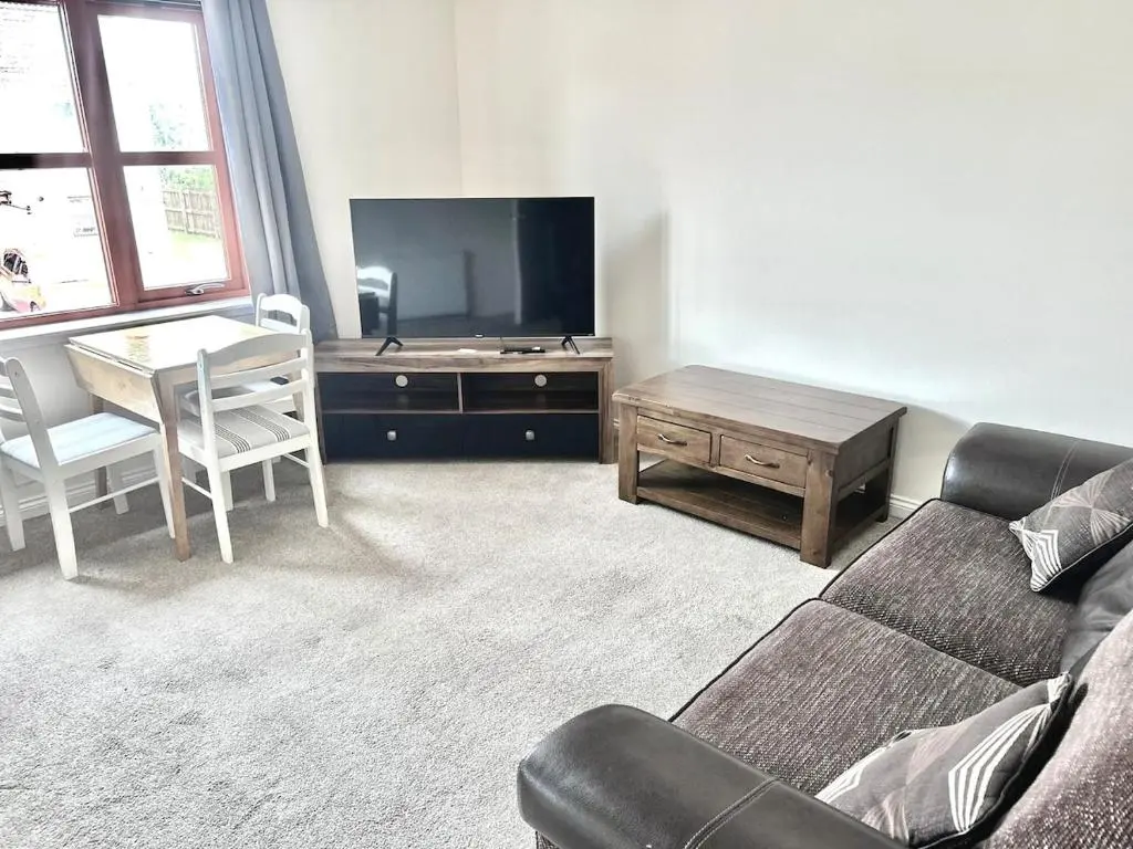 a living room with a couch and a table and a television at Coz, 2Bed Central Elgin - Free parking, WiFi in Elgin