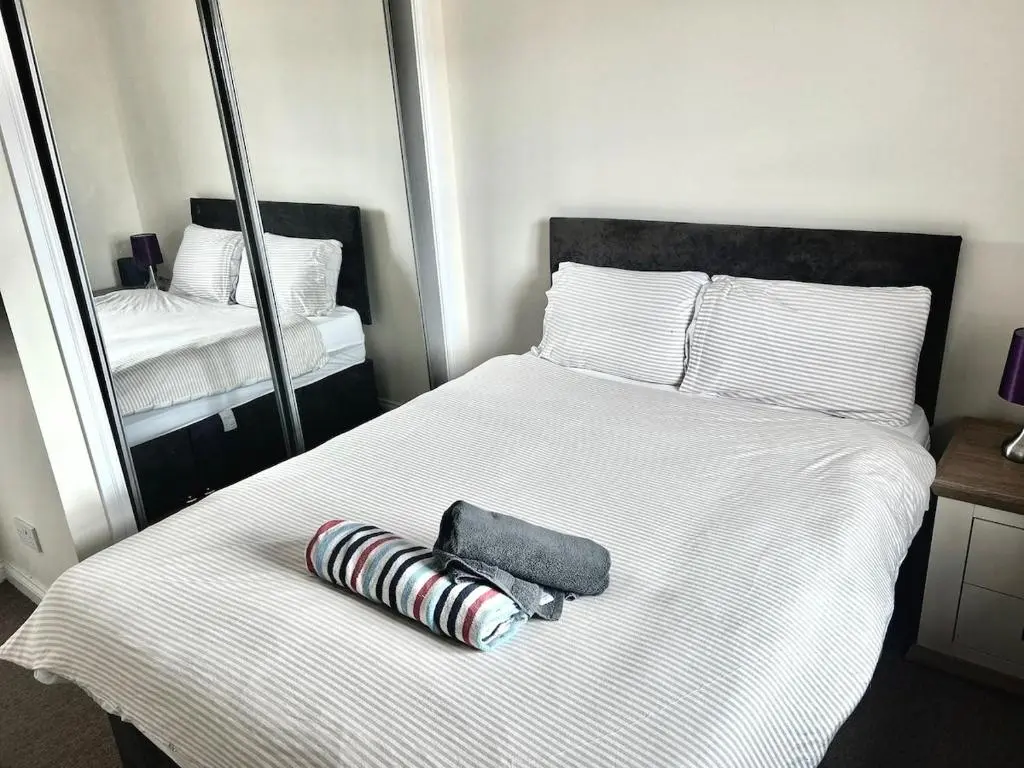 a bed with two pillows and a mirror on it at Coz, 2Bed Central Elgin - Free parking, WiFi in Elgin