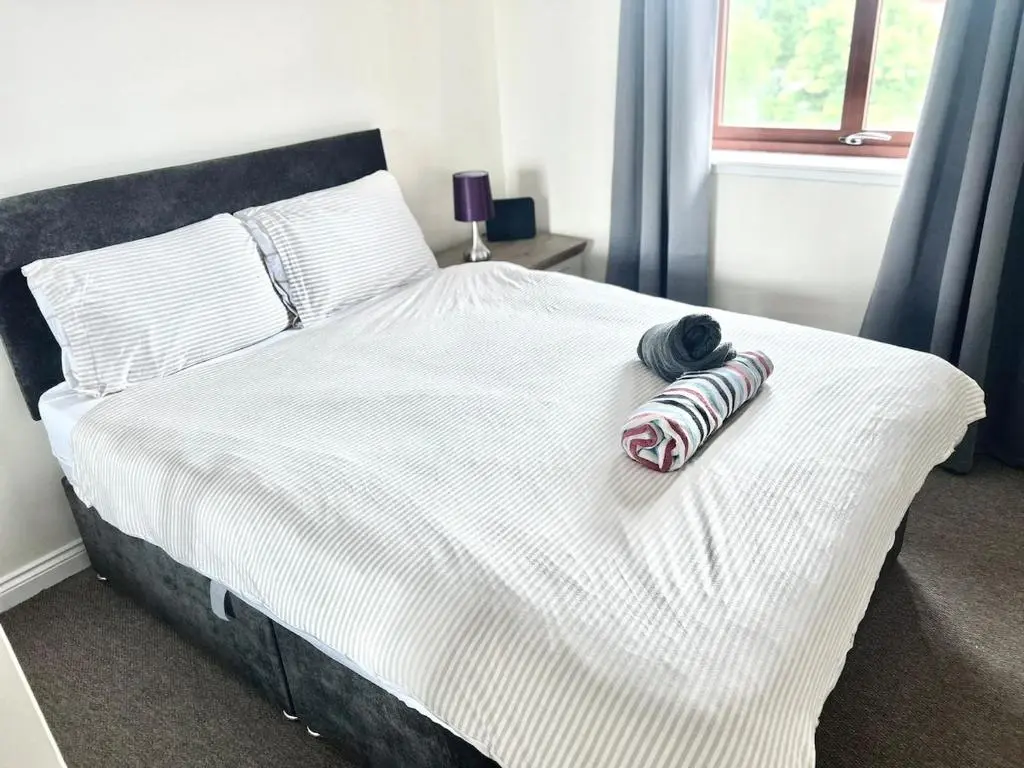 a bed with two towels on top of it at Coz, 2Bed Central Elgin - Free parking, WiFi in Elgin