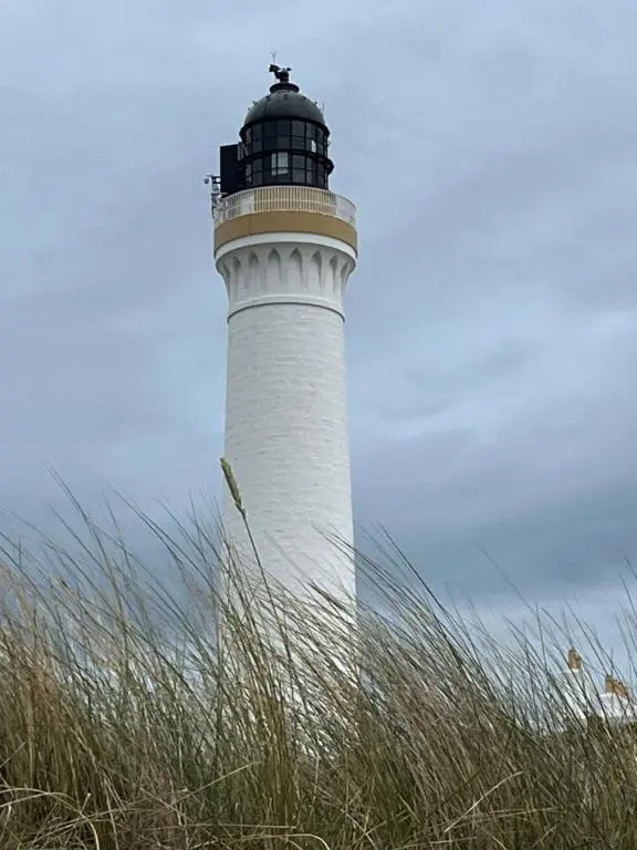 a lighthouse sitting on top of a field of grass at Covesea Horizon in Elgin