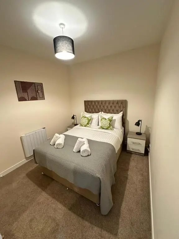 a bedroom with a bed with two towels on it at Alba Apartment in Inverness