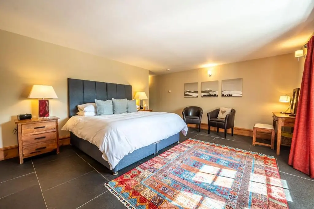 a bedroom with a large bed and a rug at Ross-shire Hall in Evanton