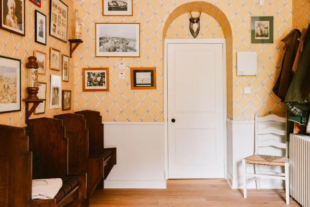 a hallway with a white door and pictures on the wall at The Secret Loch in Lhanbryd