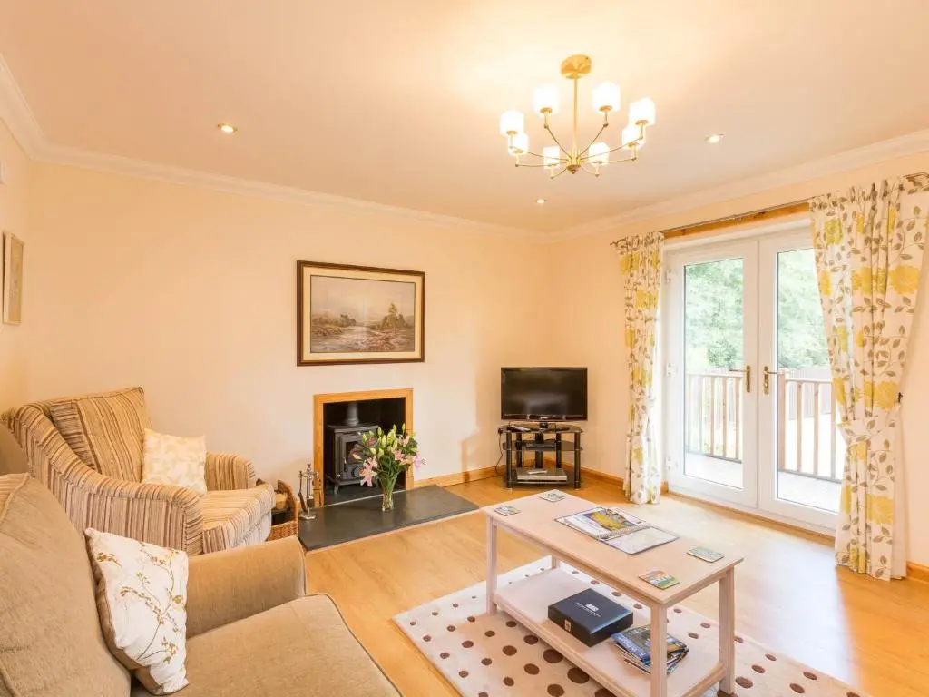a living room with a couch and a table at Broombank Cottage in Inverness