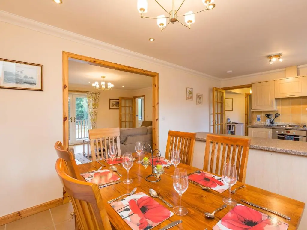 a dining room with a table with wine glasses at Broombank Cottage in Inverness