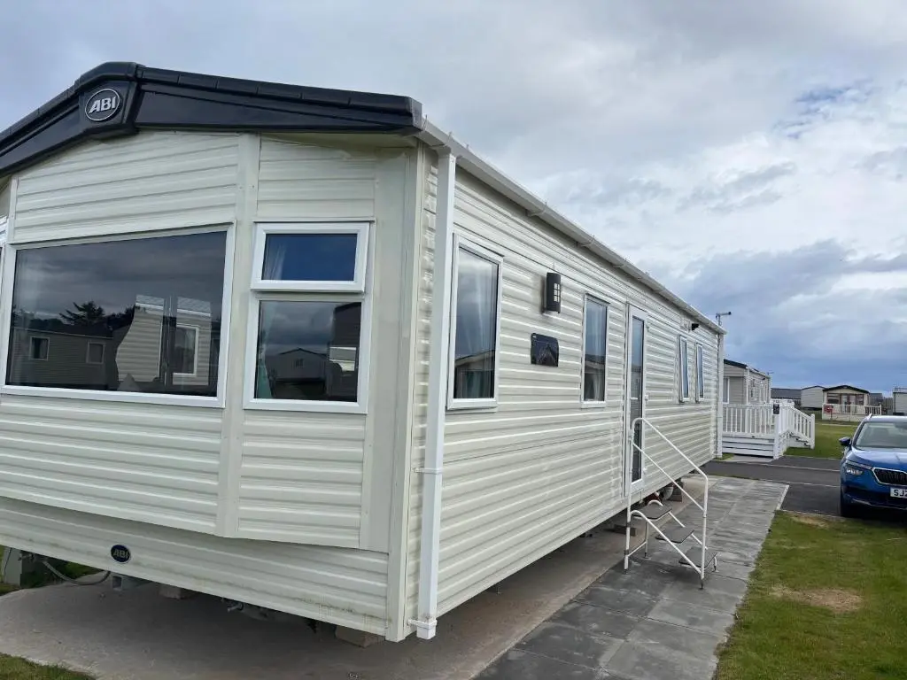 a white trailer is parked in a parking lot at Lighthouse View in Lossiemouth