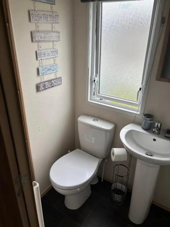 a small bathroom with a toilet and a sink at Lighthouse View in Lossiemouth