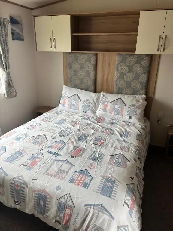 a bed with a comforter and pillows on it at Lighthouse View in Lossiemouth