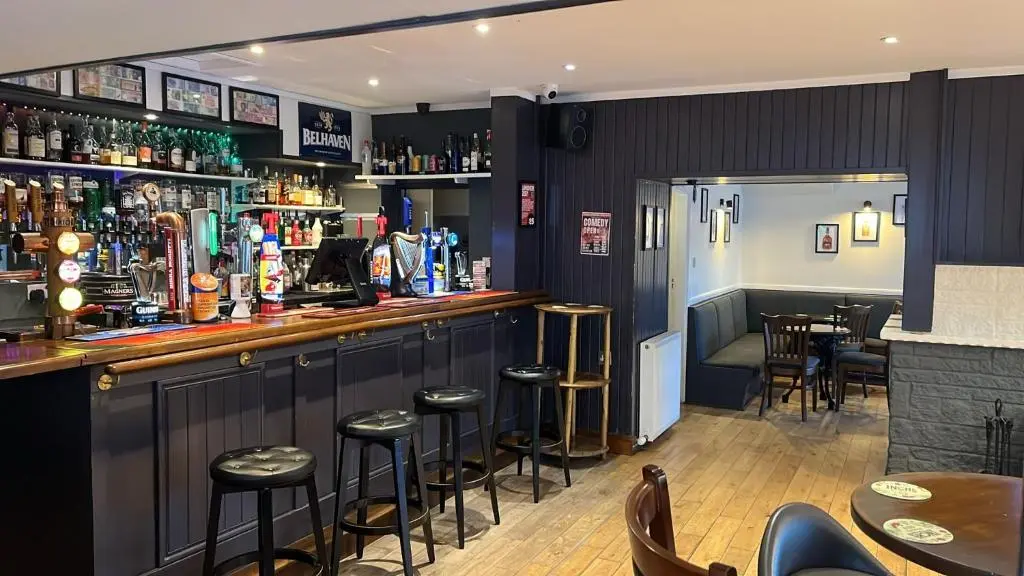 a bar in a restaurant with stools at Novar Arms Hotel in Evanton