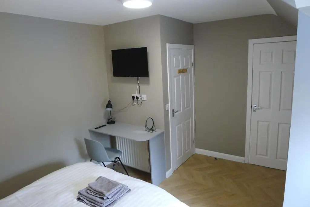 a bedroom with a bed and a desk and a tv at Hanover st partment in Fraserburgh